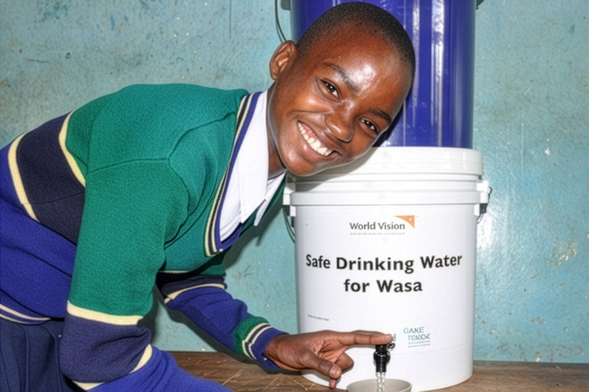 African boy filling a glass of purified water smiling into the camera.
